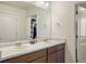 Bathroom with double sinks and a large mirror, next to the walk-in closet at 45810 Laceleaf Dr, Bennett, CO 80102