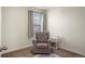 Cozy bedroom featuring a comfortable chair, soft lighting, and carpet at 45810 Laceleaf Dr, Bennett, CO 80102