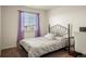 Cozy bedroom with plush carpet, a decorative metal headboard, and natural light from the window at 45810 Laceleaf Dr, Bennett, CO 80102