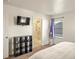 Bedroom with neutral walls, carpet, and a TV mounted on the wall at 45810 Laceleaf Dr, Bennett, CO 80102