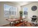 Bright dining area with a wooden table and bench, complemented by natural light and modern decor at 45810 Laceleaf Dr, Bennett, CO 80102