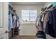 Walk-in closet with organized clothing racks and storage, and a bright window at 45810 Laceleaf Dr, Bennett, CO 80102