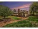 Beautiful brick home featuring a spacious backyard with a brick patio and lush green lawn under a colorful sunset at 1900 Magnolia St, Denver, CO 80220