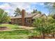 Lovely brick home featuring a spacious backyard with a brick patio, and lush green lawn on a sunny day at 1900 Magnolia St, Denver, CO 80220
