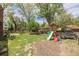 Spacious backyard includes a playset, trees, and grassy area at 1900 Magnolia St, Denver, CO 80220
