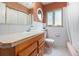 Bright bathroom with a white tile, round mirror and pink toilet at 1900 Magnolia St, Denver, CO 80220