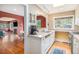 Bright kitchen with stainless steel appliances, white cabinetry, and a view through the window into the living area at 1900 Magnolia St, Denver, CO 80220