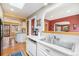 Spacious kitchen with an island, stainless steel sink, white cabinetry, and a view to the living areas at 1900 Magnolia St, Denver, CO 80220