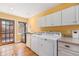 Functional laundry room with modern appliances, white cabinets, and access to the outdoors through a glass door at 1900 Magnolia St, Denver, CO 80220