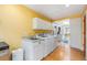 Laundry room boasts modern appliances, white cabinetry, lots of natural light and view to another room at 1900 Magnolia St, Denver, CO 80220