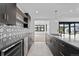Modern kitchen with dark cabinetry, geometric tile backsplash, and wine cooler at 8077 Raphael Ln, Littleton, CO 80125