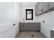 Laundry room with gray cabinets, quartz countertop and herringbone tile floor at 8077 Raphael Ln, Littleton, CO 80125
