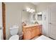 Well-lit bathroom featuring a vanity with a granite countertop, a large mirror, and a toilet at 17497 Nature Walk Trl # 302, Parker, CO 80134