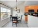 Bright dining area featuring a modern light fixture, breakfast bar, and kitchen access at 17497 Nature Walk Trl # 302, Parker, CO 80134
