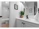 Bathroom featuring a modern vanity with black hardware, framed mirror, and a shower-tub with white tile surround at 12054 E 3Rd Ave, Aurora, CO 80011