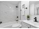 Modern bathroom with a marble-look tile shower, black fixtures, and a white vanity with black hardware at 12054 E 3Rd Ave, Aurora, CO 80011
