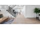 Entryway featuring wood-look floors, stairs with a black iron railing, and an open view into the kitchen at 12054 E 3Rd Ave, Aurora, CO 80011