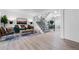 Bright living room features a teal sofa, wood floors, and a black iron staircase at 12054 E 3Rd Ave, Aurora, CO 80011