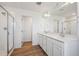 Well-lit bathroom features a double sink vanity with wood-look flooring and a glass-enclosed shower at 9081 Telluride Ct, Commerce City, CO 80022