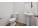 Clean half bath featuring a pedestal sink, a toilet, and neutral finishes at 9081 Telluride Ct, Commerce City, CO 80022