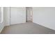 Neutral carpeted room with sliding closet doors and an open entrance at 9081 Telluride Ct, Commerce City, CO 80022