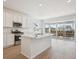 Modern kitchen with white cabinets, stainless steel appliances, and a large island with a sink at 9081 Telluride Ct, Commerce City, CO 80022