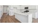 Modern kitchen with white cabinets, stainless steel appliances, and a large island with a sink at 9081 Telluride Ct, Commerce City, CO 80022