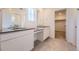 Modern bathroom featuring double sinks, vanity, and tile flooring with a view of a walk-in closet at 662 N Clubview St, Watkins, CO 80137