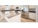 Spacious kitchen with an island, stainless steel refrigerator, white cabinets and countertop, and wood-style floors at 662 N Clubview St, Watkins, CO 80137