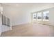 Bright living room showcasing wood-style floors, large windows and staircase with black metal balusters at 662 N Clubview St, Watkins, CO 80137