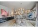 Stylish dining area with a glass table, modern chandelier, and open layout at 1571 S Trenton Ct, Denver, CO 80231