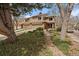 View of a charming two-story home nestled among mature trees and lush landscaping at 1571 S Trenton Ct, Denver, CO 80231