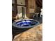 Enclosed hot tub on a wooden deck, featuring blue and white tiling inside and brick pillars surrounding it at 1571 S Trenton Ct, Denver, CO 80231