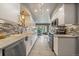 Modern kitchen featuring sleek white cabinetry, stainless steel appliances, and stylish backsplash at 1571 S Trenton Ct, Denver, CO 80231
