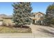 Two-story brick home with a large driveway and landscaping at 2457 S Xenon Way, Denver, CO 80228