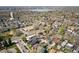 An aerial view displays a residential area with mature trees, diverse architecture, and a distant lake at 2921 Newton St, Denver, CO 80211