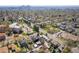 An aerial view reveals a vibrant city neighborhood with tree-lined streets and a distant skyline at 2921 Newton St, Denver, CO 80211