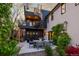 Outdoor patio area featuring a modern seating area, dining table, spiral staircase, and lush landscaping at 2921 Newton St, Denver, CO 80211
