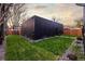 A landscaped backyard features a modern dwelling, gravel accents, and a lush lawn at 2921 Newton St, Denver, CO 80211