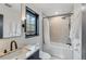 Well-lit bathroom featuring bathtub with shower, vanity with white marble, and decorative mirror at 2921 Newton St, Denver, CO 80211
