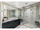 Spacious bathroom with dual shower heads, glass door, vanity, and large mirror at 2921 Newton St, Denver, CO 80211