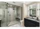 Elegant bathroom featuring walk-in shower, vanity with dark cabinets, and modern fixtures at 2921 Newton St, Denver, CO 80211