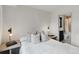 Bright bedroom featuring white walls, soft bedding, and side table with books at 2921 Newton St, Denver, CO 80211