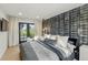 Bright bedroom with gray bedding, accent wall, and door to outside spiral staircase at 2921 Newton St, Denver, CO 80211