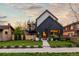 Striking two-story modern home featuring dark siding, manicured lawn, and sidewalk leading to the entrance at 2921 Newton St, Denver, CO 80211