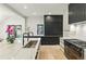 Sleek, modern kitchen boasting black and white cabinetry and professional-grade appliances at 2921 Newton St, Denver, CO 80211