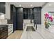 Elegant kitchen featuring white cabinetry, black accents, and a spacious marble island at 2921 Newton St, Denver, CO 80211