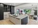 Open kitchen featuring a large island, sleek cabinetry, stylish lighting, and an open flow to the living area at 2921 Newton St, Denver, CO 80211