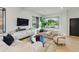 Sunlit living room with comfortable seating, modern console, and a view of the landscaped outdoors at 2921 Newton St, Denver, CO 80211