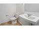 Minimalist bathroom with pedestal sink, toilet, and laminate flooring for a clean design at 17123 W 91St Ln, Arvada, CO 80007